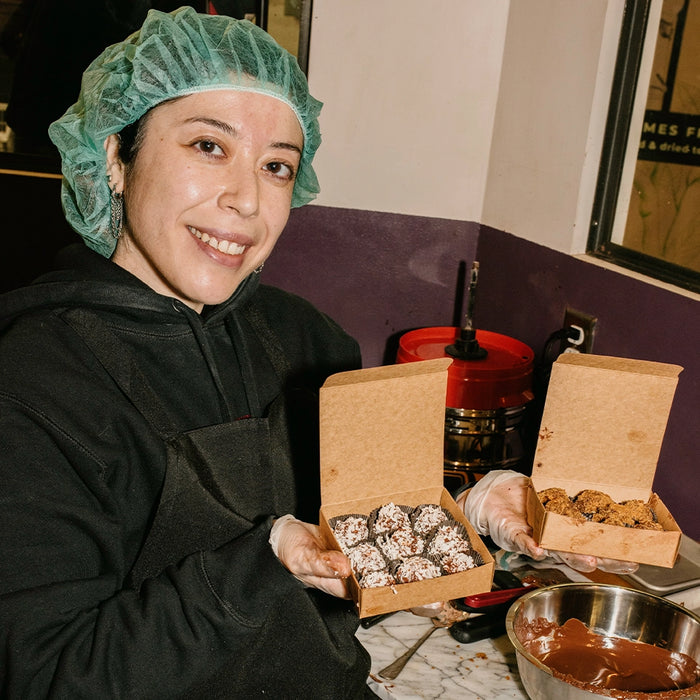 Person holding two boxes of truffles in a classroom setting