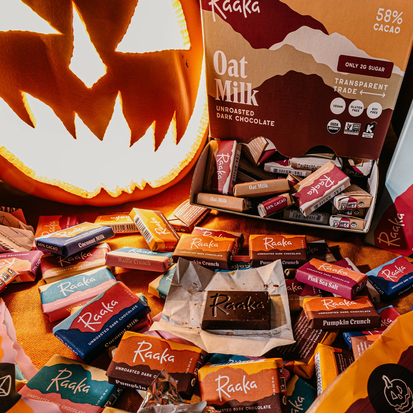 Assorted Raaka Mini Chocolate Bars with a pumpkin in the background