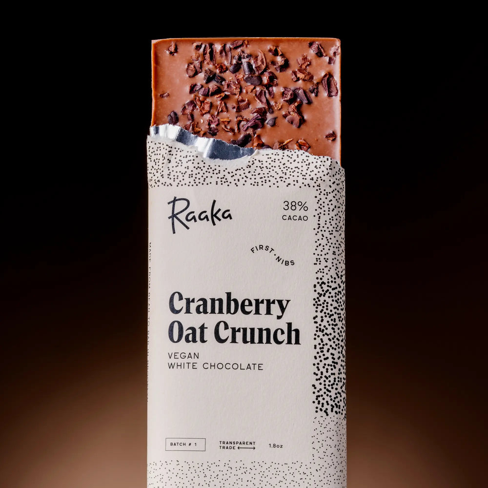 Raaka Cranberry Oat Crunch vegan white chocolate bar on a dark background