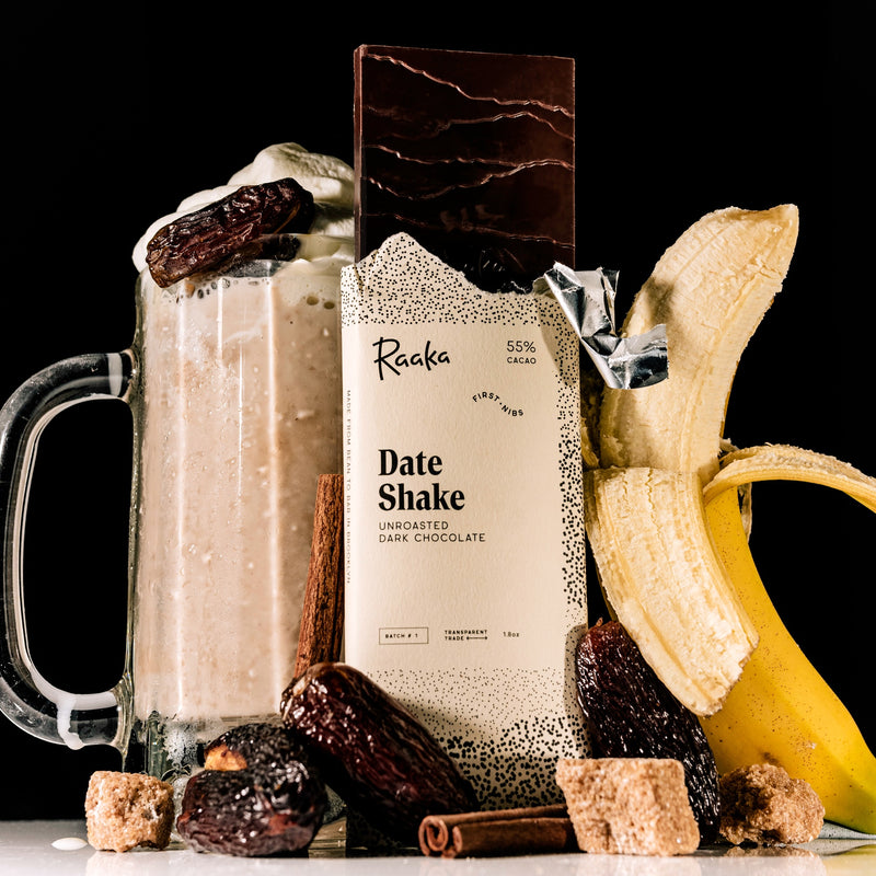 Date shake with a Raaka Date Shake bar, banana, and dates on a black background