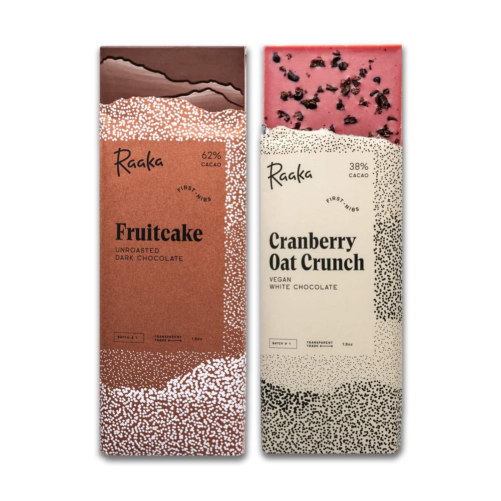 Two Raaka chocolate bars, one fruitcake and one cranberry oat crunch, on a white background.