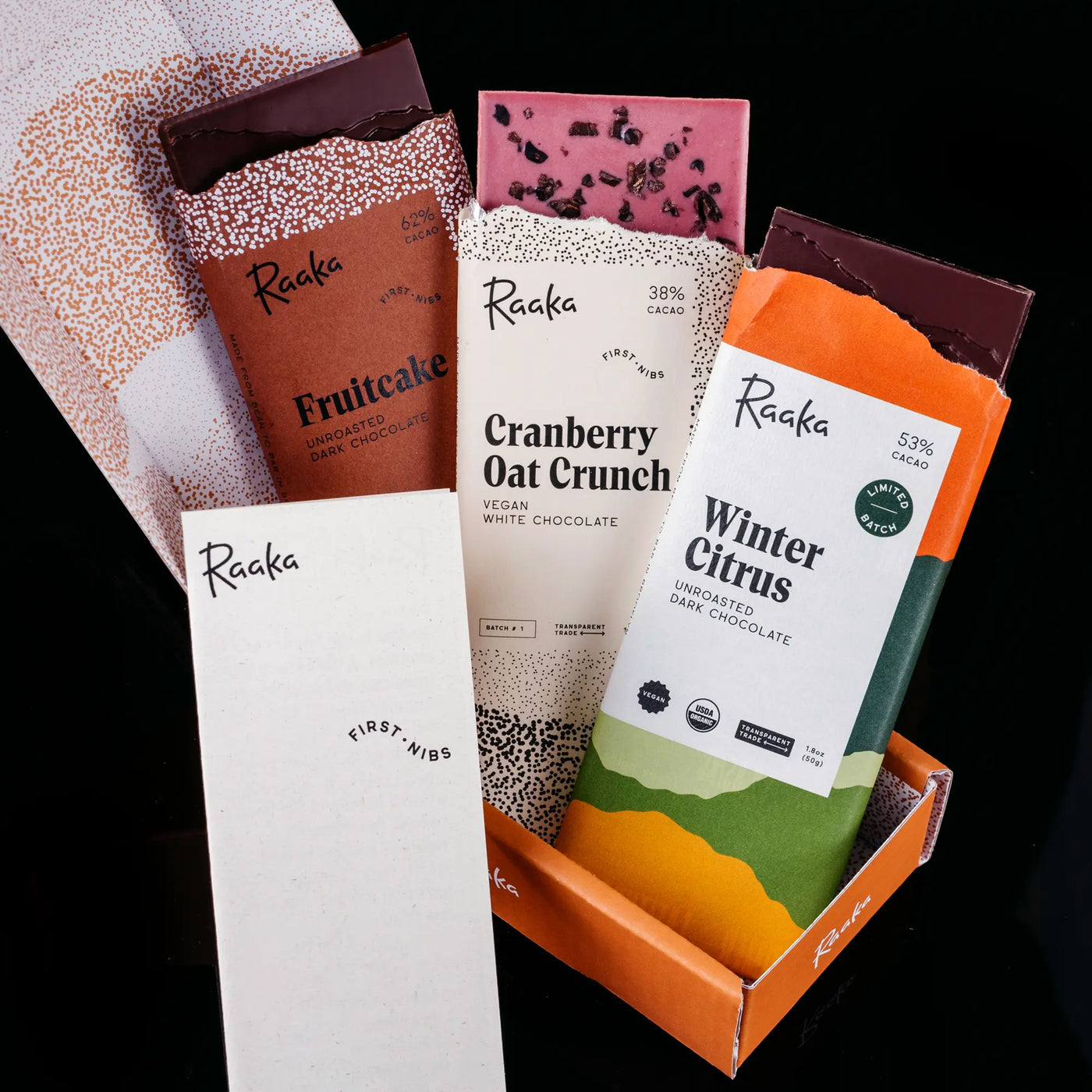 December's First Nibs bars in their box: Fruitcake, Cranberry Oat Crunch, and Winter Citrus. 