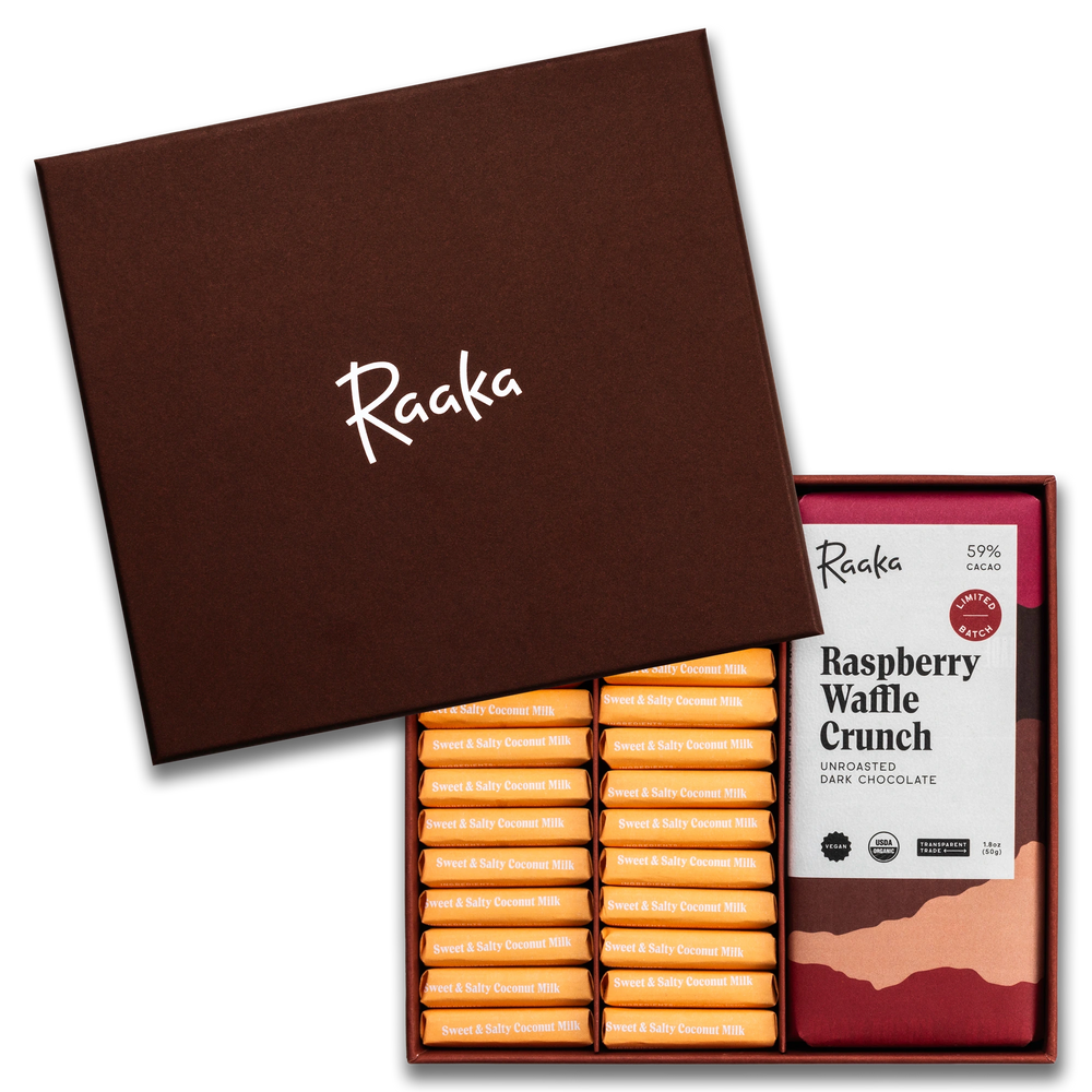 Open box of Raaka chocolate bars with a single Raspberry Waffle Crunch bar displayed.