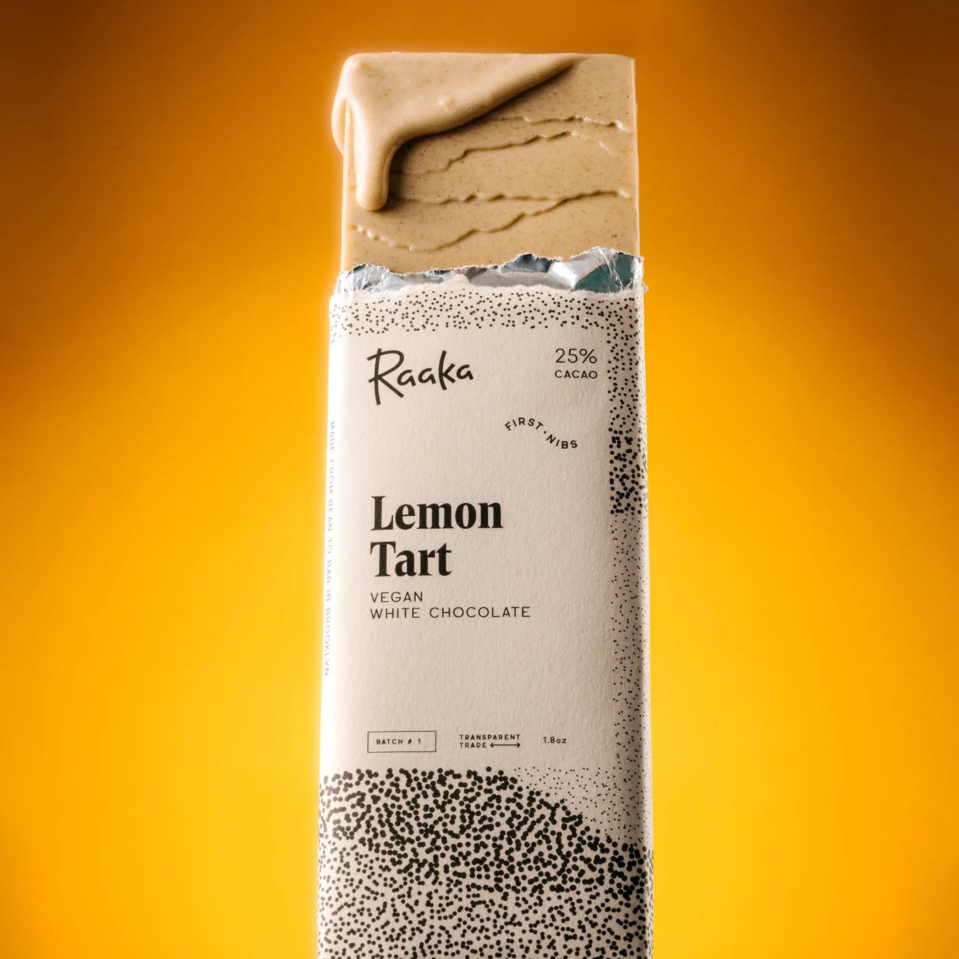 Raaka Vegan Lemon Tart Chocolate Bar on a gradient yellow orange background