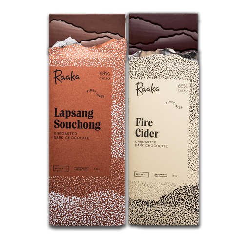 Two Raaka chocolate bars, in October's First Nibs batch: one 'Lapsang Souchong' and the other 'Fire Cider', on a white background.