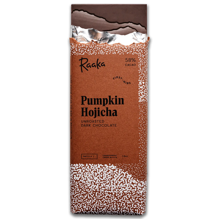 A single wrapped chocolate bar package labeled 'Raaka Pumpkin Hojicha' on a plain white background. The wrapper is predominantly warm brown with white speckled decorative areas near the top and bottom and a dark chocolate section at the top.