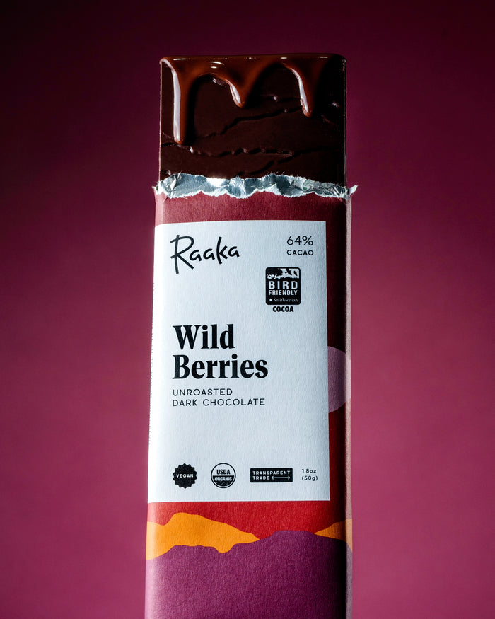 Raaka Wild Berries unroasted dark chocolate bar on a purple background