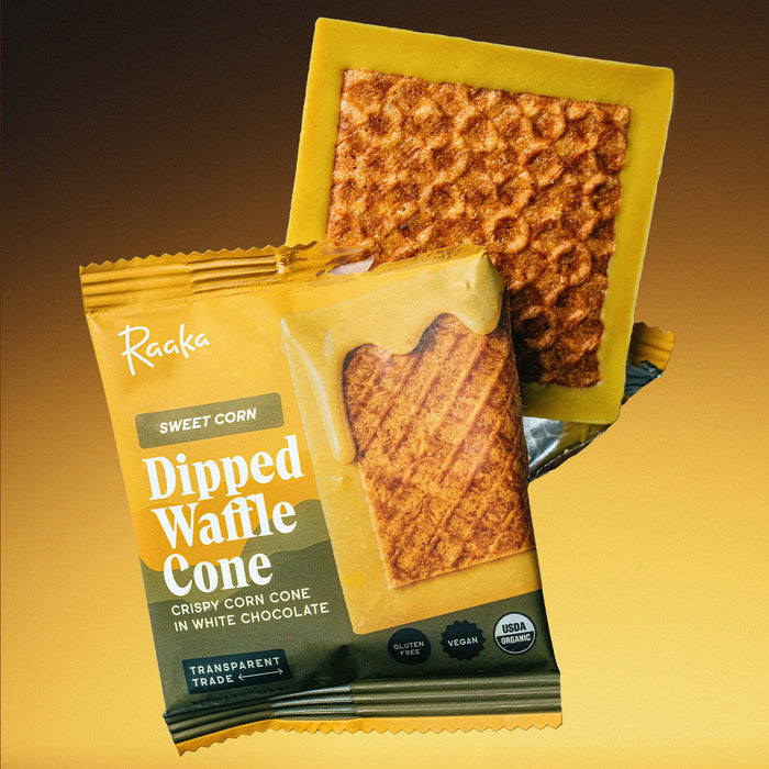 Sweet Corn Dipped Waffle ConE sticking out of packaging on yellow gradient background. 