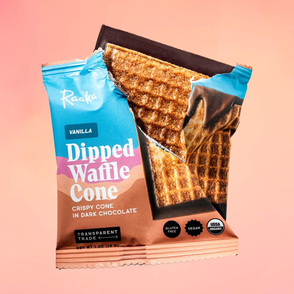 Packaged vanilla dipped waffle cone with Raaka branding on a pink background.