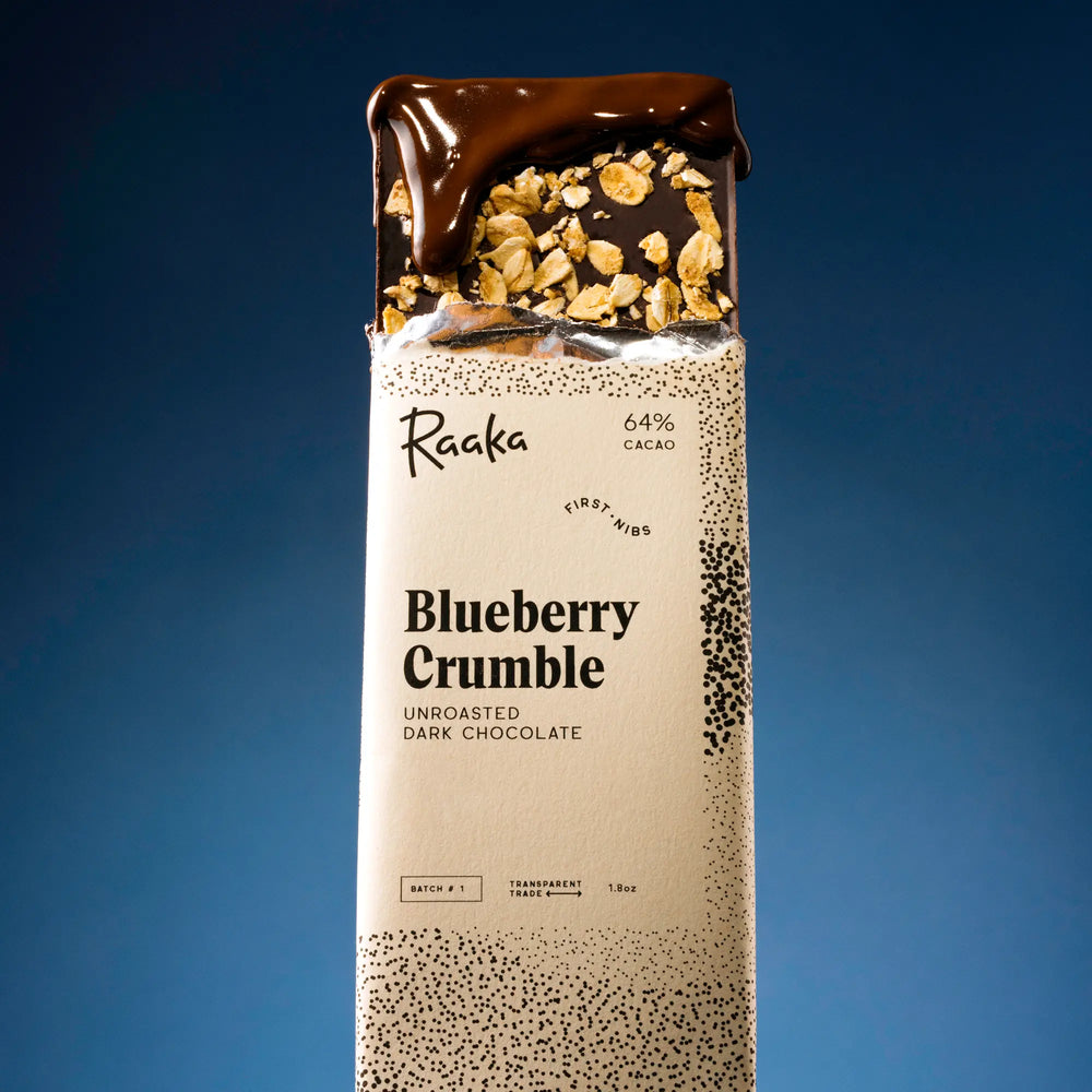 Raaka Blueberry Crumble chocolate bar packaging on a blue background