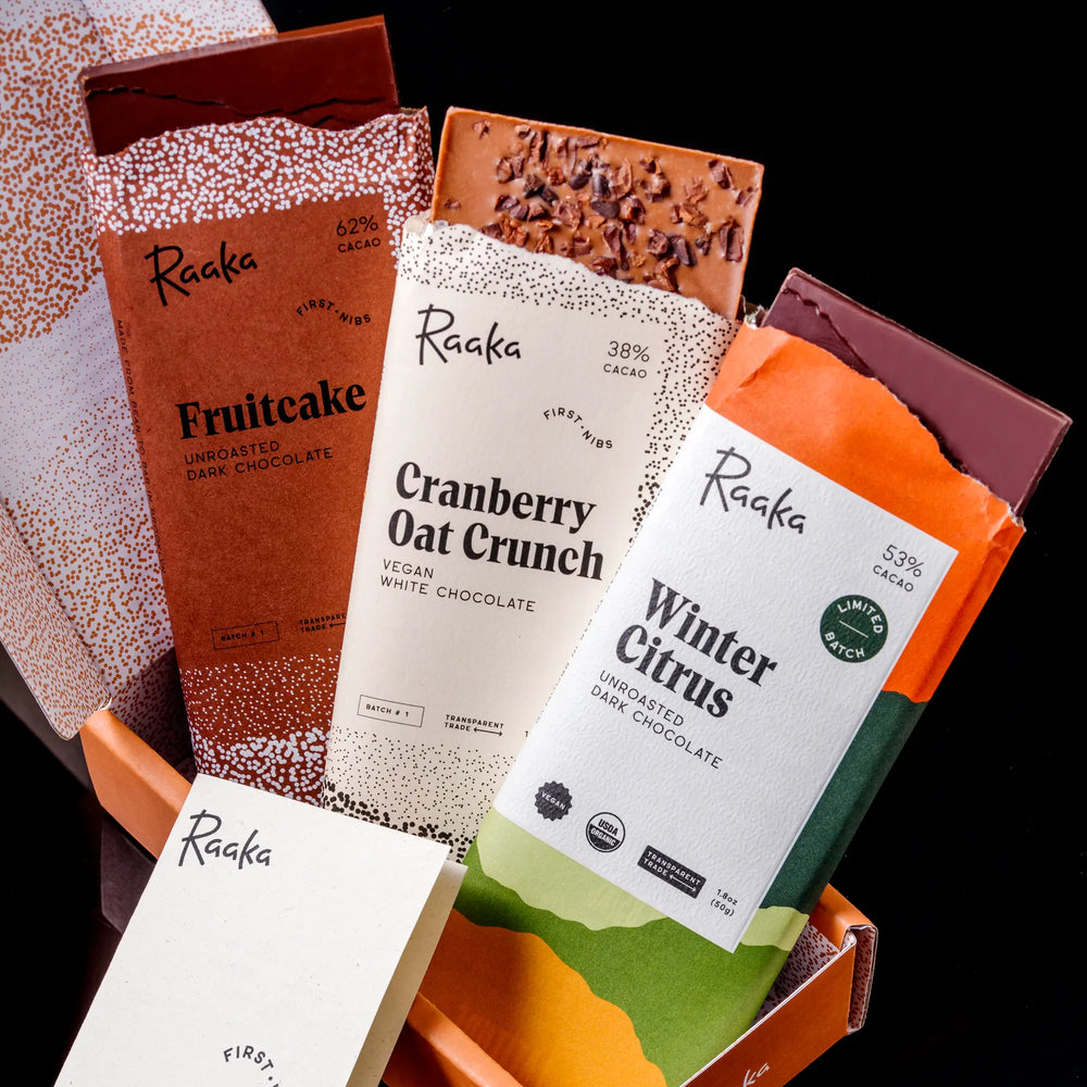 Assorted Raaka chocolate bars with visible packaging on a black background
