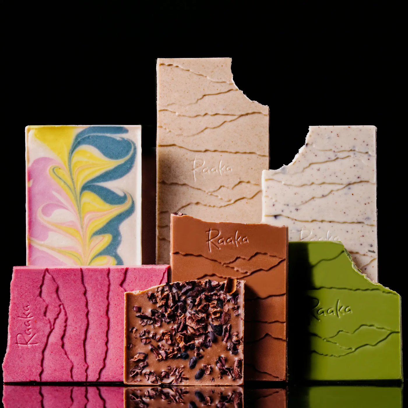 Assorted chocolate bars with different textures and colors on a black background